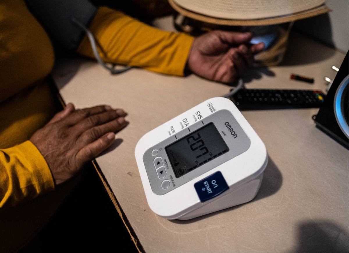 Personne utilisant un tensiomètre à domicile.