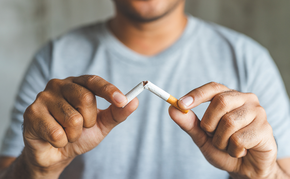 cutting cigarettes by scissors. Anti smoking or quit smoking concept Stock Photo Close-up of man's hand cutting
