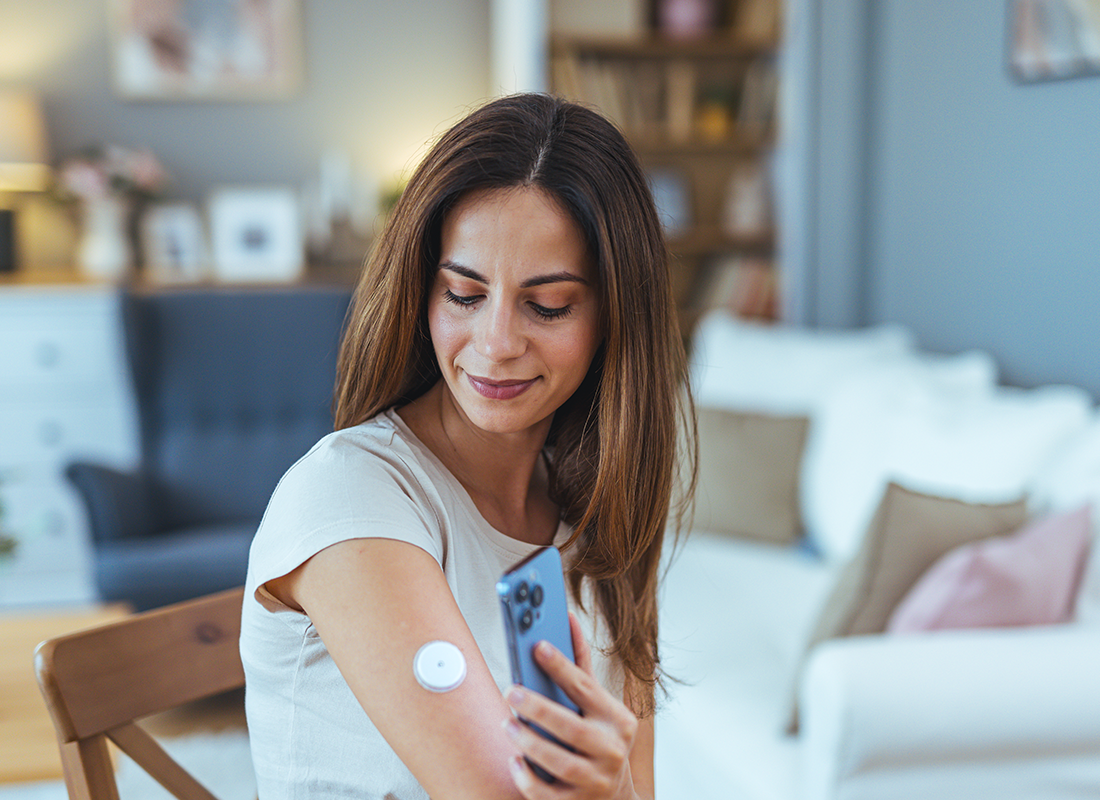 Femme vérifiant son capteur de glucose avec son smartphone