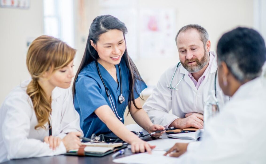 Un médecin examine des dossiers médicaux avec ses collègues
