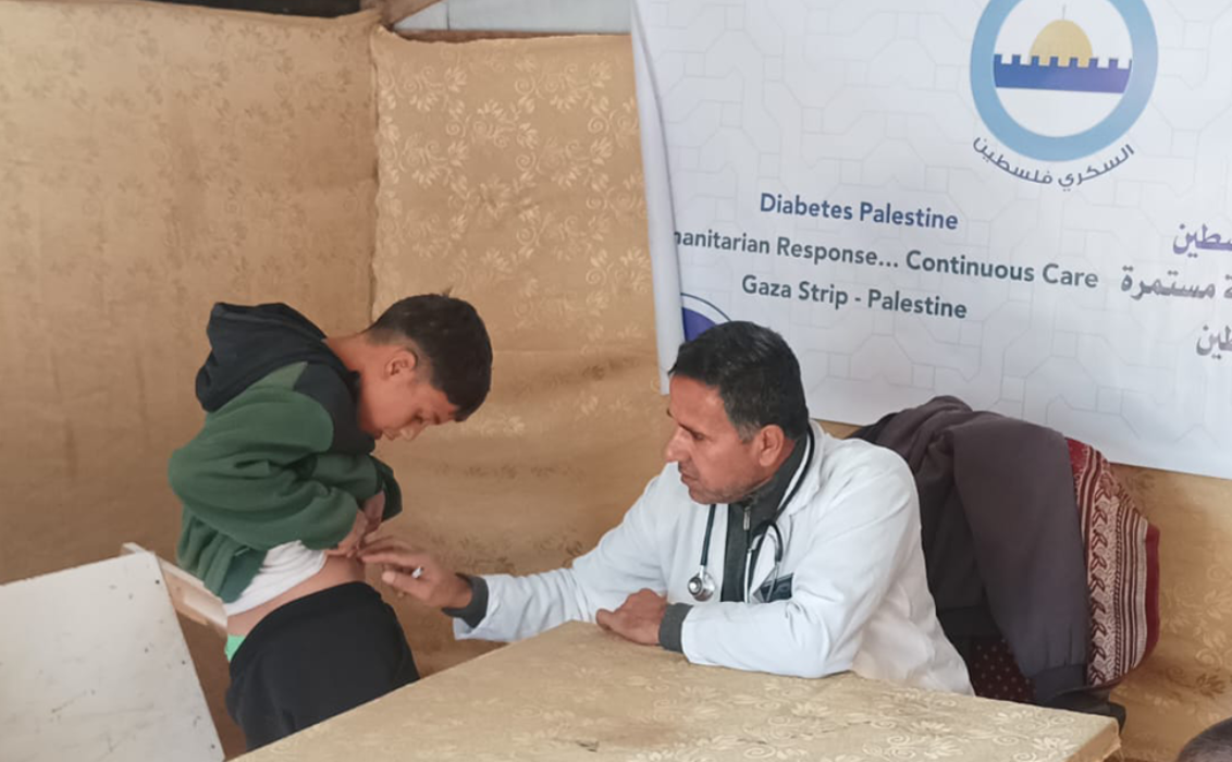 Médico que atiende a un niño con diabetes en una clínica de Diabetes Palestine